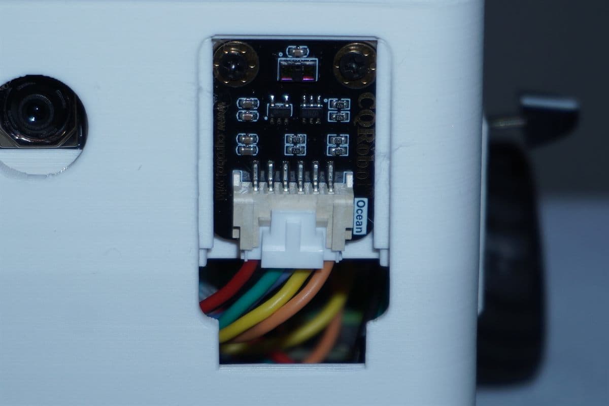 The distance sensor beside the camera lens, with the wiring loom running back into the shell