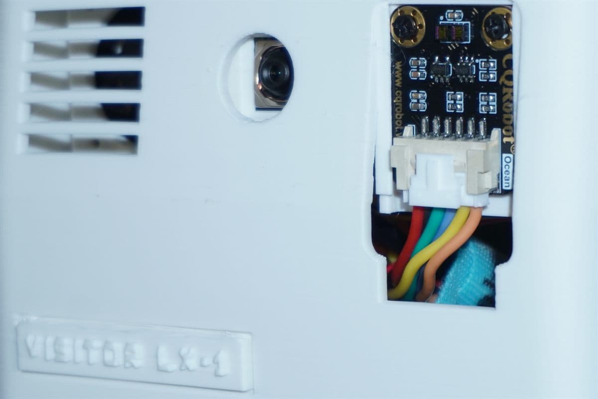The cooling vent, camera and distance sensor across the front face, with VISITOR LX-1 embossed below